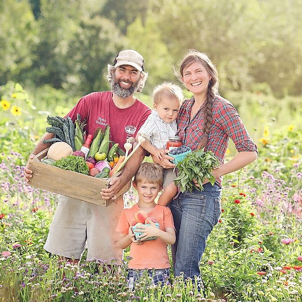 Red Fire Farm owners Ryan and Sarah Voiland with their family holding their bounty. 